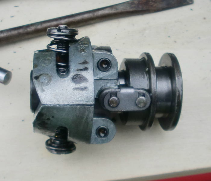 der abgenommene Regler, links die Fliehgewichte mit Druckfedern, mitte die Zugösen, rechts der Mitnehmer für den Schleifring des Reglergestänges